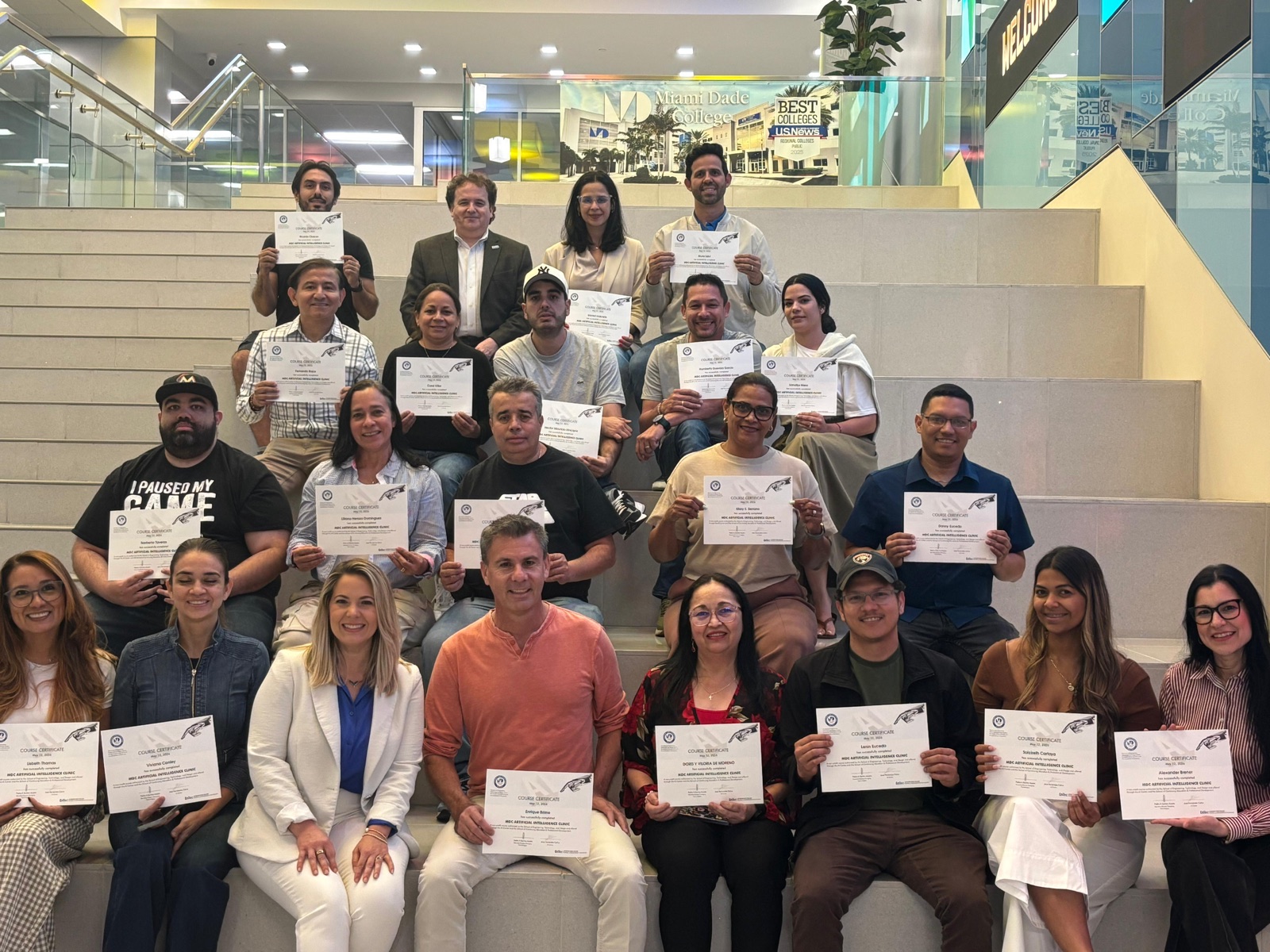 A full AI Clinic class holding their course certificates on the stairs at Miami Dade College West Campus