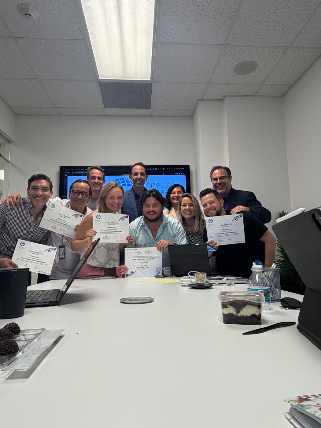 The Conexsol solar company team holding their AI course certificates in their conference room